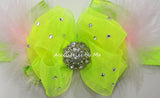 Neon green hair bow with rhinestones, layered with pink marabao feathers on a white background